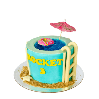 A colorful dog birthday cake swimming pool featuring a blue pool design and a pink umbrella decoration.