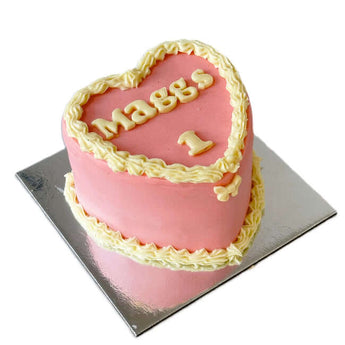 4" heart shaped dog birthday cake decorated with pink icing and lettering for a dog's special day.
