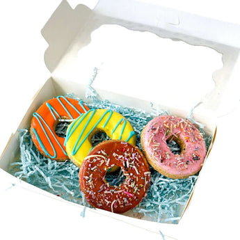 Handcrafted dog biscuits in a colorful box with sprinkles and iced decorations for your pampered pup.