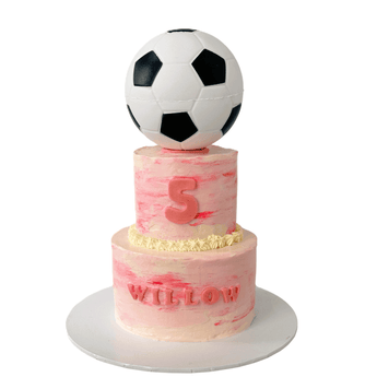 2-tier dog birthday cake in ombré style topped with a soccer ball, perfect for a dog party.