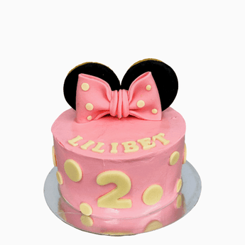 Minnie Mouse dog birthday cake decorated with a cute bow and oversized ears for a dog party.