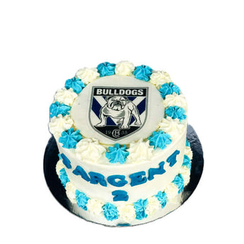 Dog sports team birthday cake with Bulldogs logo and blue frosting for dog party.