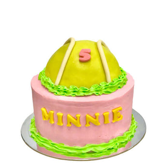 Dog birthday tennis ball cake for Minnie featuring pink and green icing with a yellow tennis ball top.