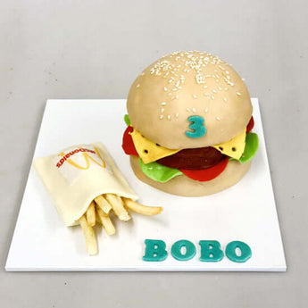 Dog birthday cake shaped like a burger with fries, perfect for celebrating your furry friend's special day.