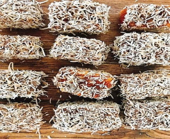 Handcrafted dog cake lamingtons coated in shredded coconut, perfect for any dog's birthday party!