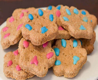 Delicious paw print dog cookies decorated with blue and pink icing, perfect for your dog party or dog birthday cake.