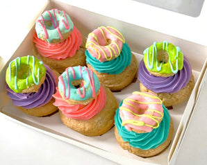 Dog-friendly pupcakes in a box, topped with vibrant frosting and colorful sprinkles for a dog birthday cake.